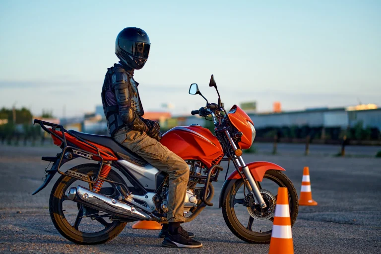 Motoristi suojavarusteissa ja kuulonsuojaimet, harjoittelee liikenteessä.